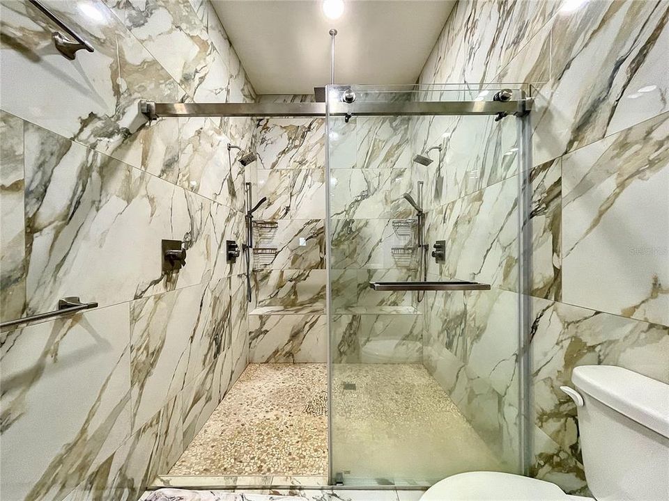 Luxury dual wall shower heads, rain ceiling shower head and built bench.