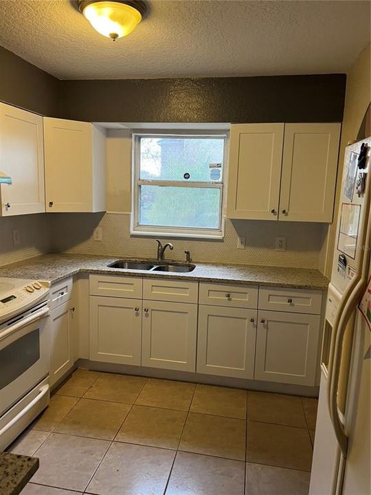 Another view of totally renovated kitchen, showing windows on top of double sink.