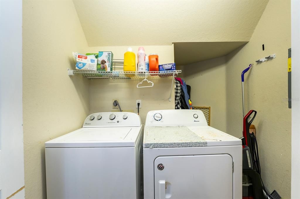 Laundry room, located next to stairs, on the left of front door.