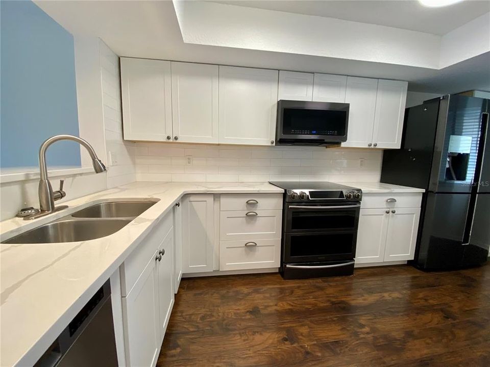 Beautifully remodeled kitchen with solid countertop and a timeless design.