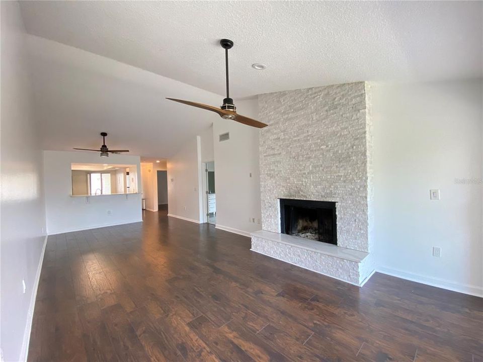 Gorgeous marble wood burning fireplace in the spacious living room/ dining room combo with vaulted ceilings.