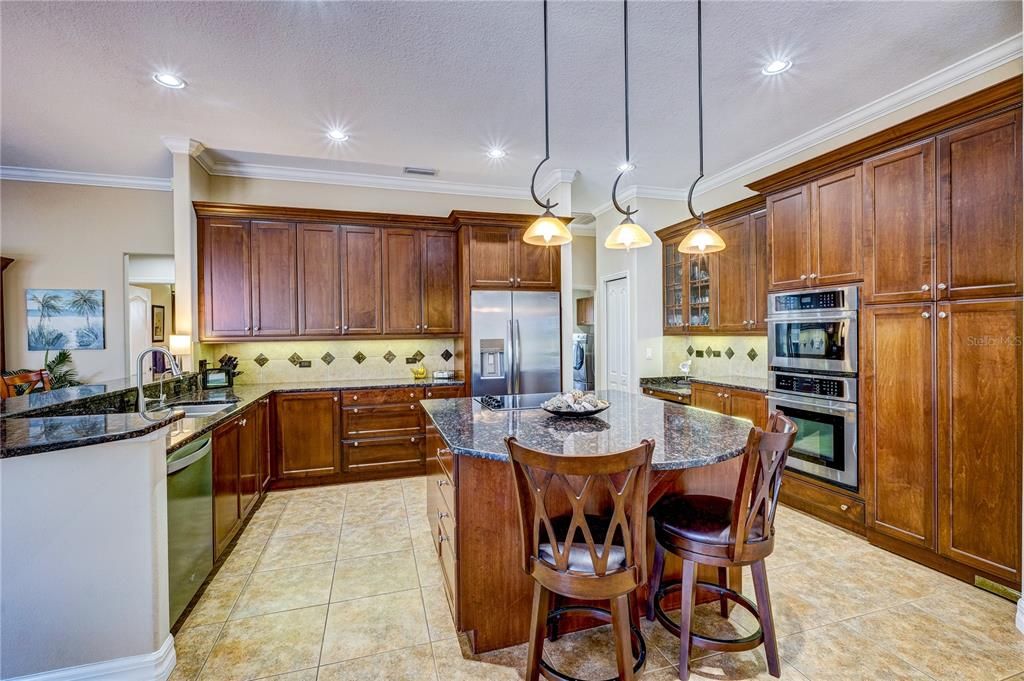 Beautiful kitchen with "hidden" walk in pantry behind the double cabinet doors to the right of the wall ovens.