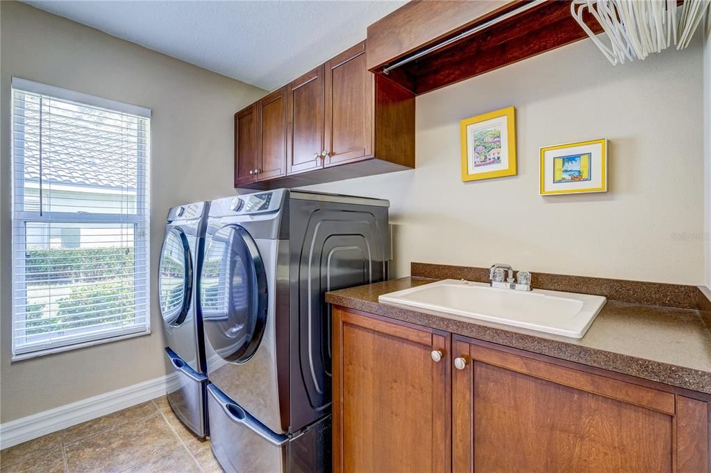Large laundry room with sink and cabinets. Opposite wall has a very large closet!