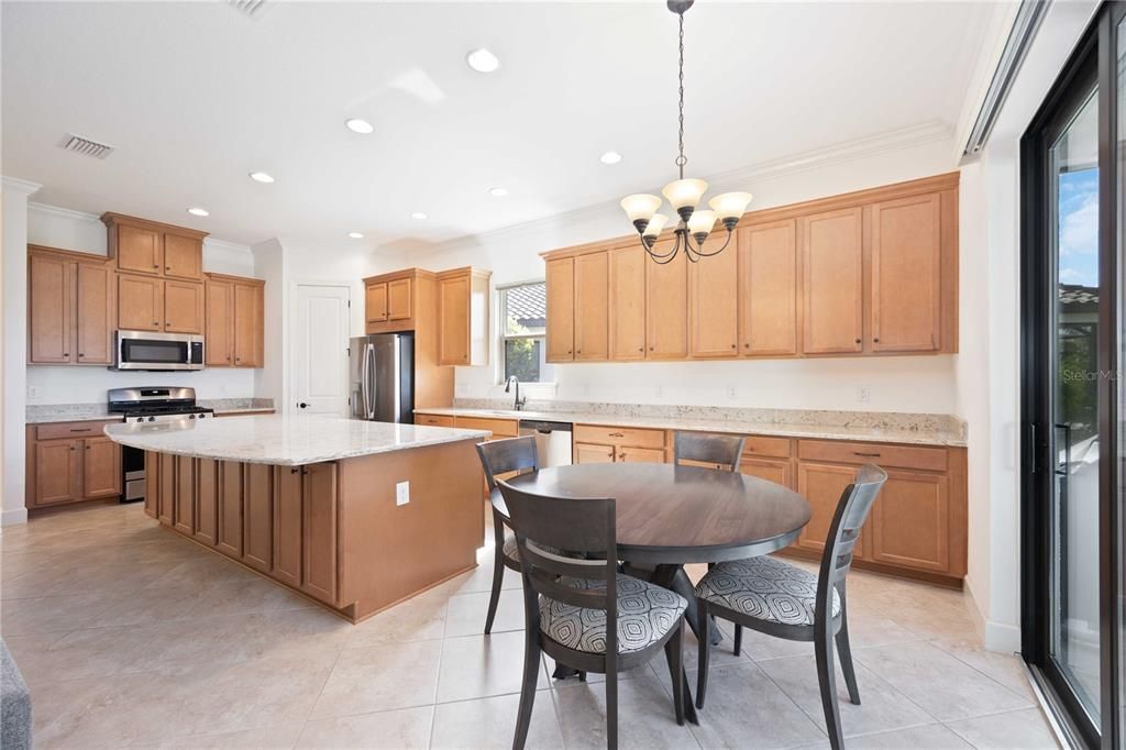 The extended kitchen has stainless stell appliances including a gas stove.