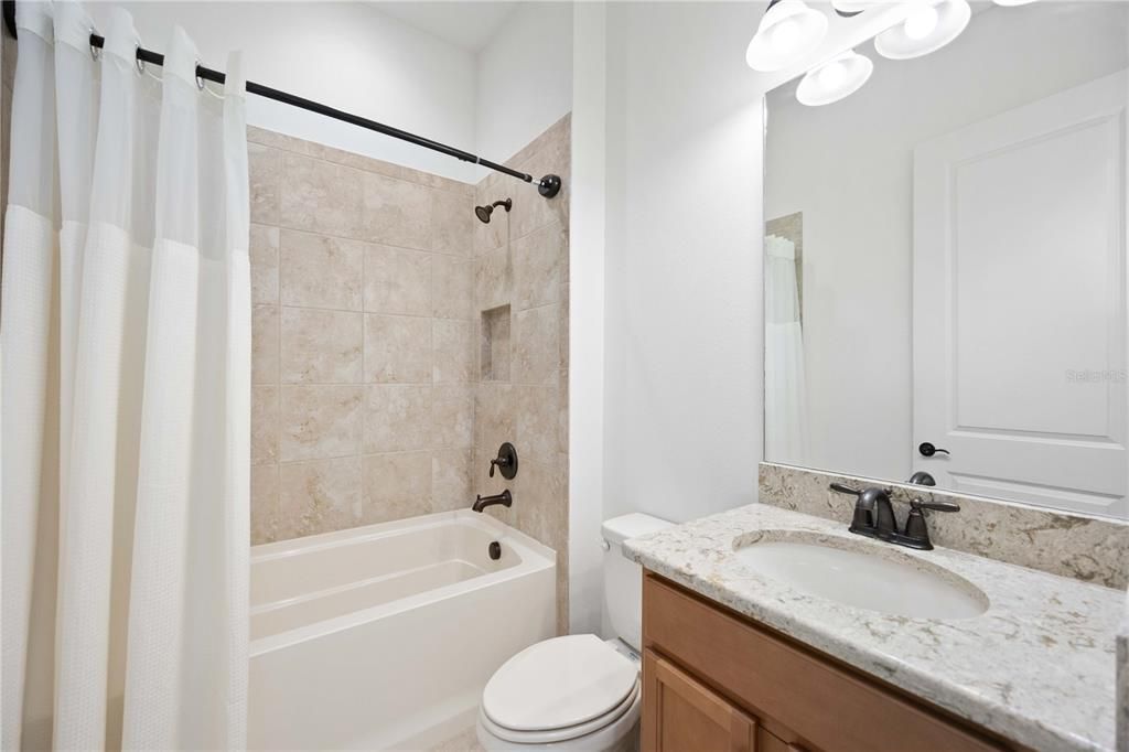 The guest bathroom is adjacent to the third bedroom and has a tub/shower.