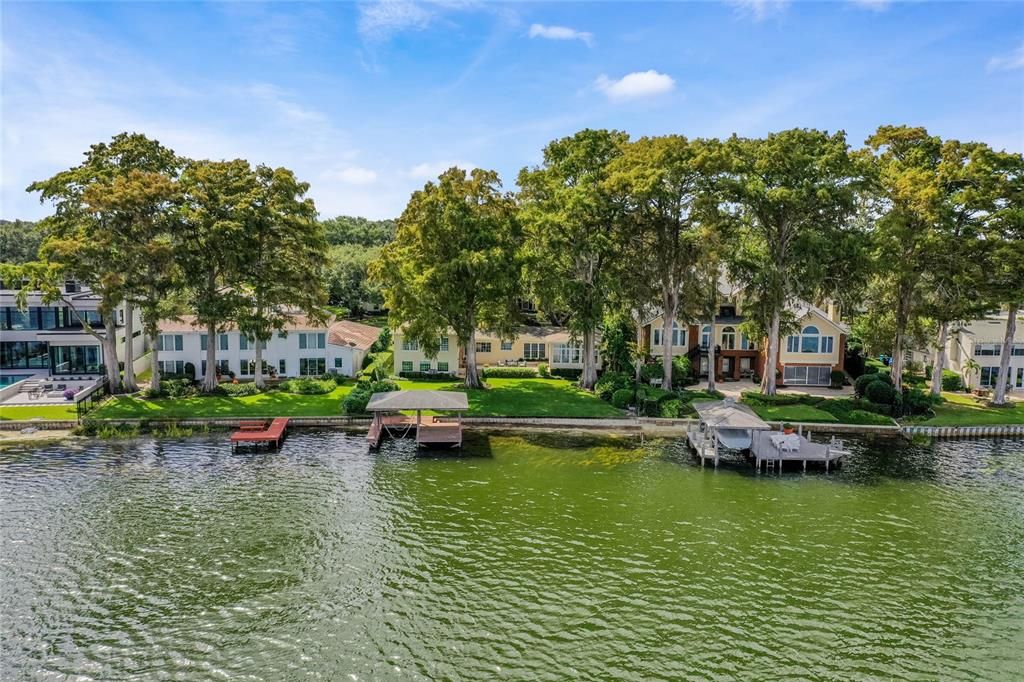 A wonderful aerial view of the dock and backyard of the home.