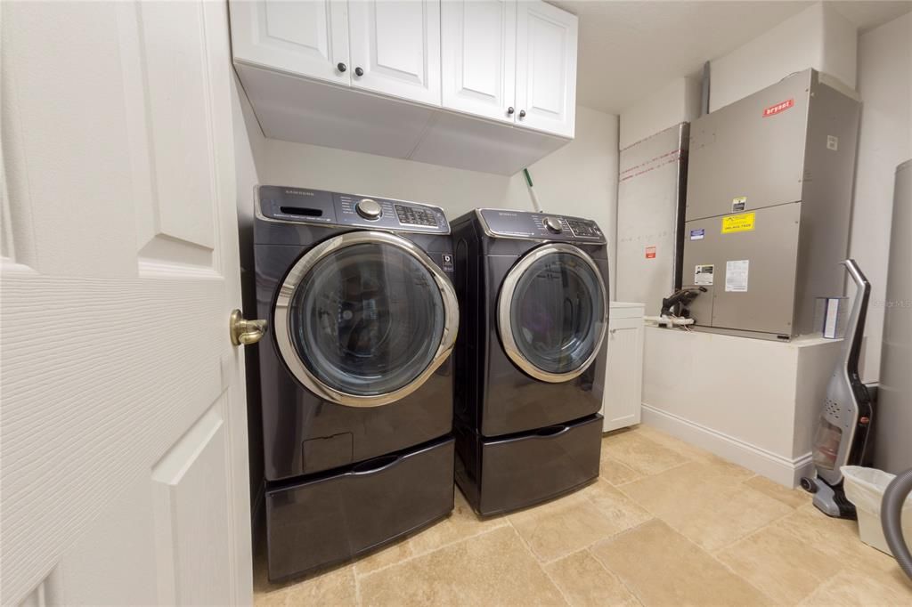 Large laundry room with utility sink and cabinets for storage