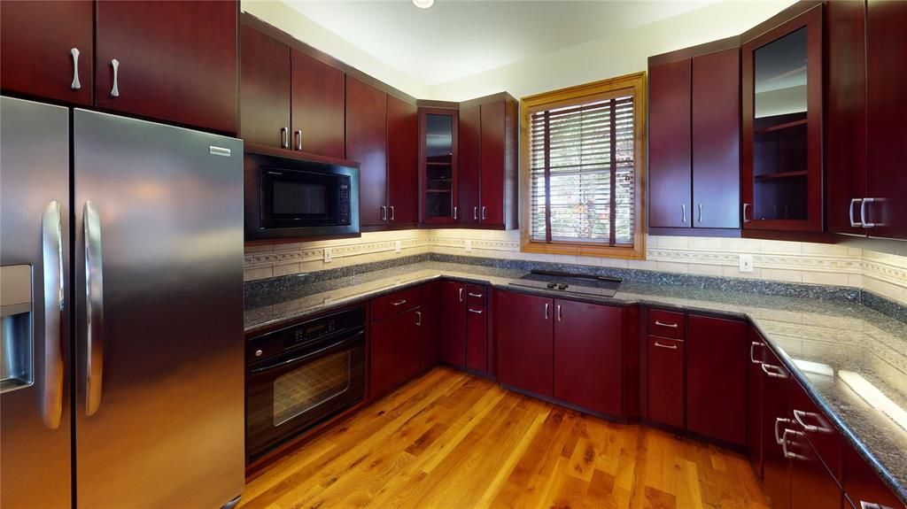 Beautiful gourmet kitchen has it all. Tons of wood cabinets, granite counters, SS appliances, under & over counter lighting & tiled backsplash.