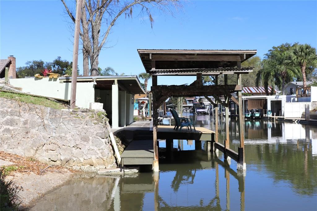 From the east end of the canal front.  The grandfathered 18' coquina rock boat ramp is to the far left.  The boat house and covered outdoor rec area/storage area