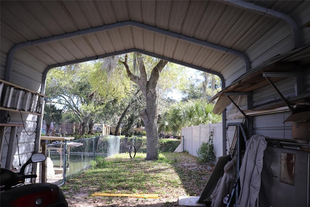 Looking out from the covered carport to the fenced in dog run area/canal