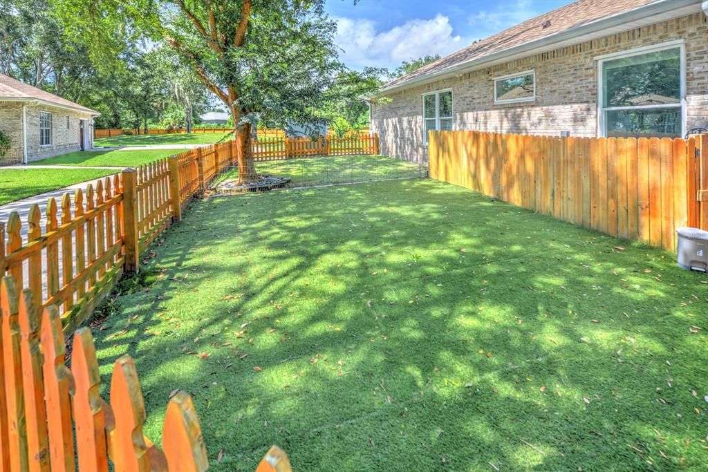 Private doggie fenced area with artificial turf.