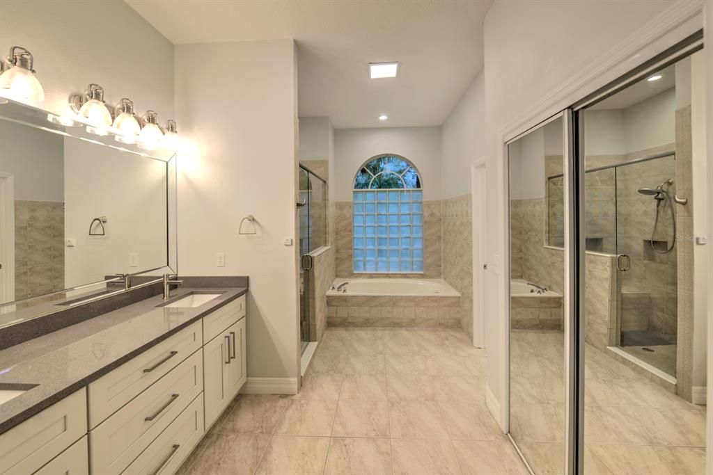 Owner's suite with double vanities, quartz counters, jetted tub, separate walk-in shower and customized walk-in closet.