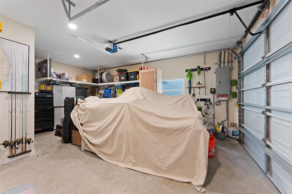 LARGE GARAGE FOR CAR OR TOY STORAGE. NOTE ALL THE RACKS THAT ARE UP HIGH. THESE ARE BUILT IN AND STAY WITH THIS HOME.