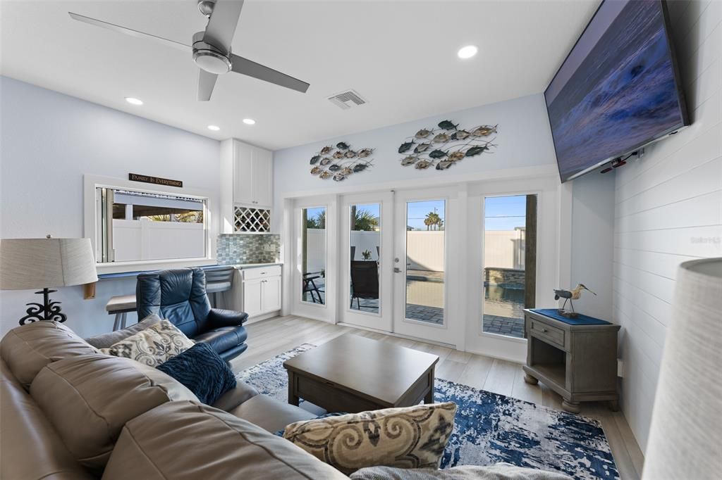 WELCOME TO THE FIRST LEVEL OF RESORT STYLE ENTERTAINING..JUST LOOK AT THE POOL AND THE INDOOR-OUTDOOR BAR....ALSO NOTE THE HIGH CEILINGD WITH THE GORGEOUS FRENCH DOOR TO THE POOL! LOVE THE SHIPLAP WALL TOO!