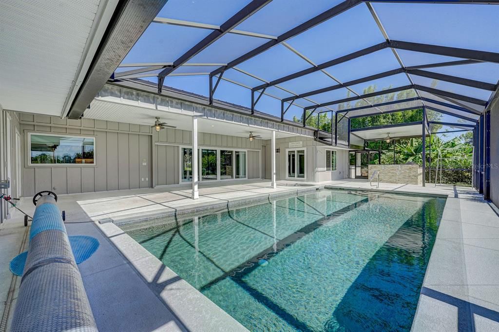 Enclosed pool. Salt Water. Heated. w/Spa.  Solar Covering rolled. Looking towards summer kitchen.