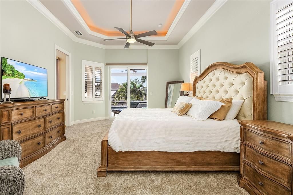 Master Bedroom with patio doors leading to lanai, tray ceiling