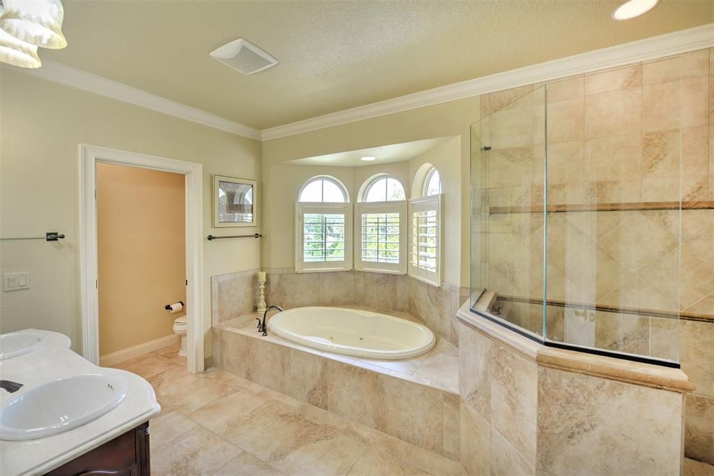 Owner's bath includes plantation shutters, tile floors, and a private water closet.