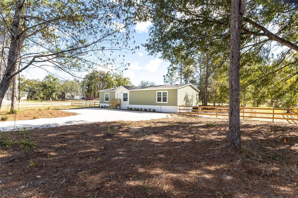 New home on a corner acre lot and paved road with wide driveway with turn around.