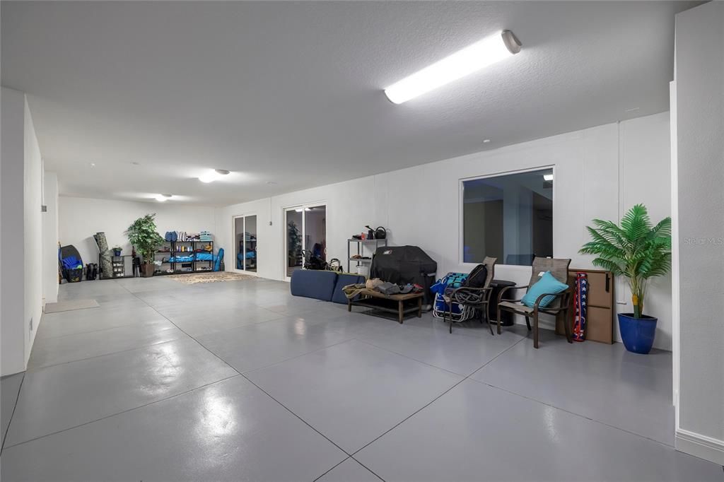 First floor garage has a two car garage door with tandem parking for up to 5 cars. Mini split air conditioner. Half bath for easy access from the pool. Can also be used for extra storage or a workshop.
