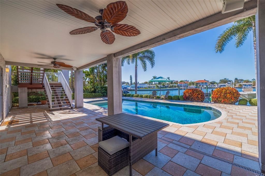 Ground Level Backyard covered patio w/ ceiling fan overlooking the in-ground heated pool.