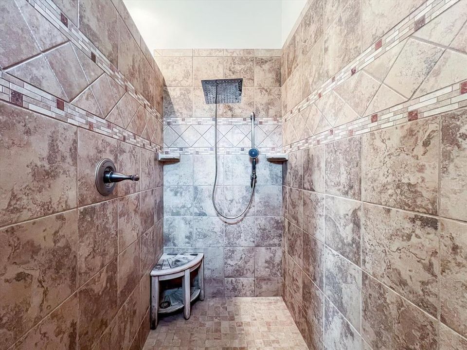 Stunning tiled walk-in shower with rain shower head.