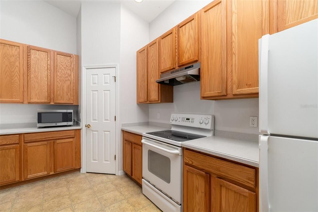 Featuring wooden cabinets, Corian countertops, and a generous sized pantry.