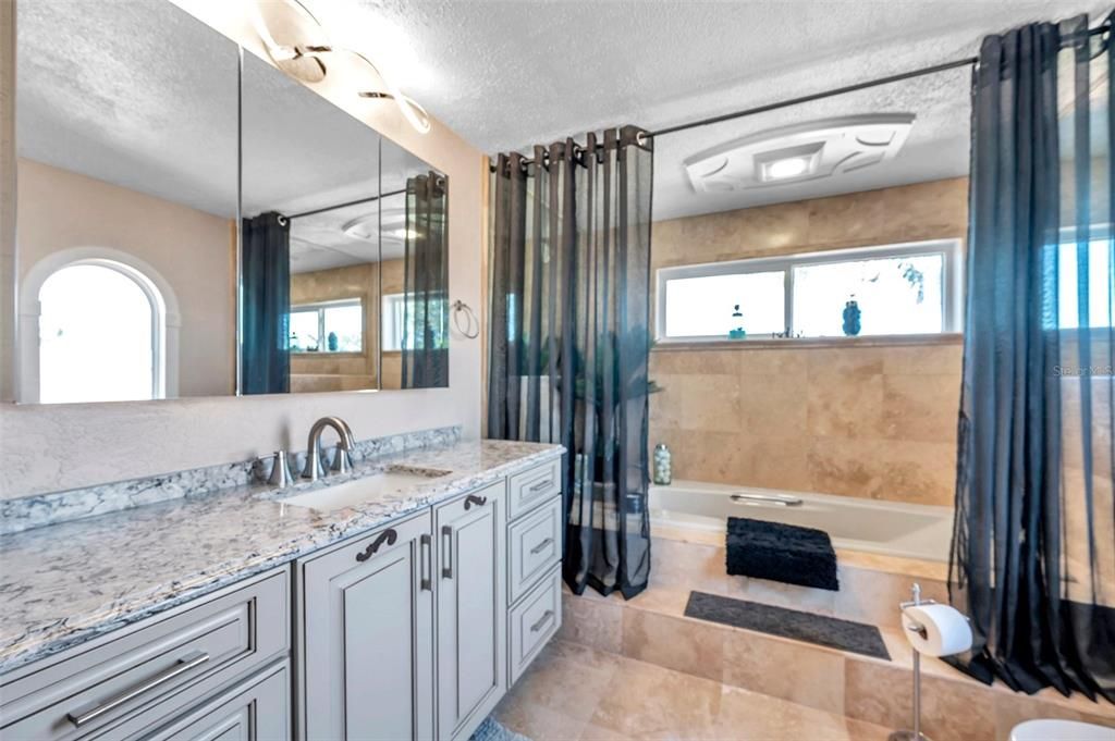 The master bathroom features two vanities a tub and a walk in shower