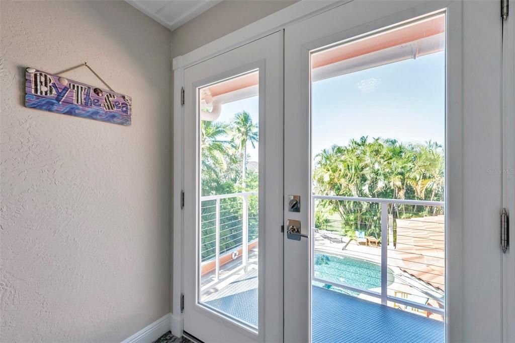 This 4th upstairs private bedroom features double doors to a balcony with partial water views