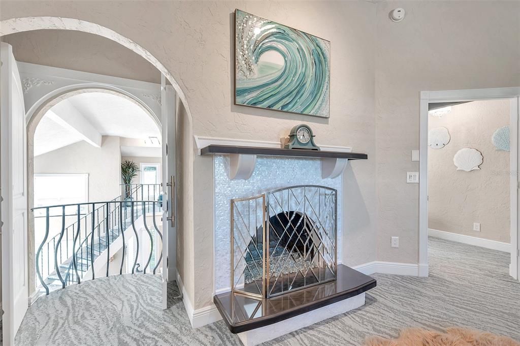 The primary bedroom features a fireplace and a balcony that overlooks the formal living room