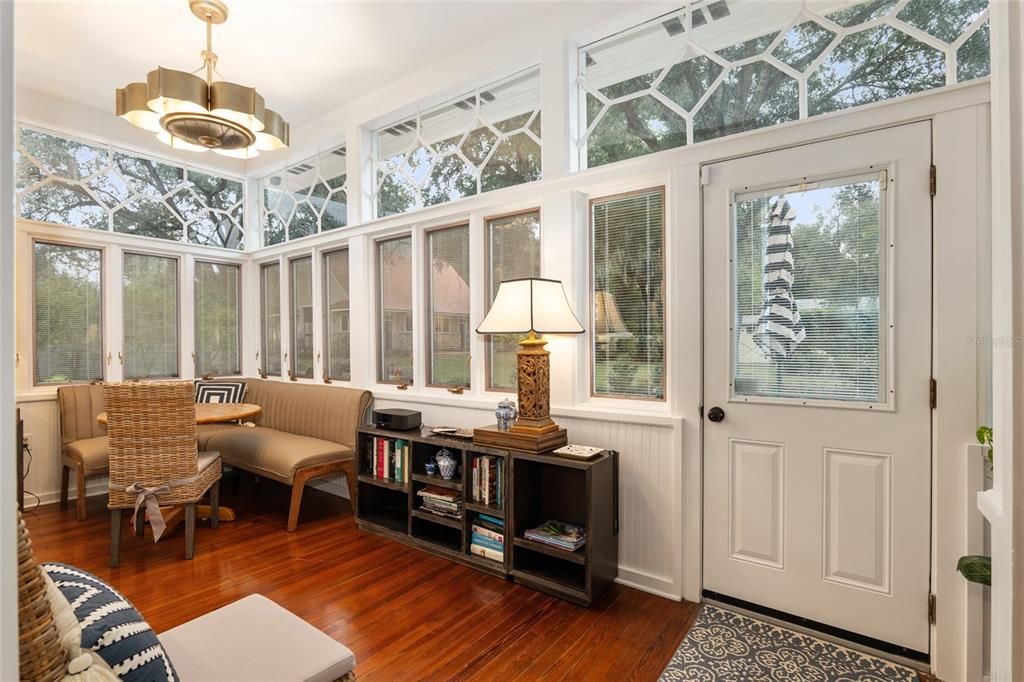 Sunroom with views of walled garden and back door adjoin a laundry room