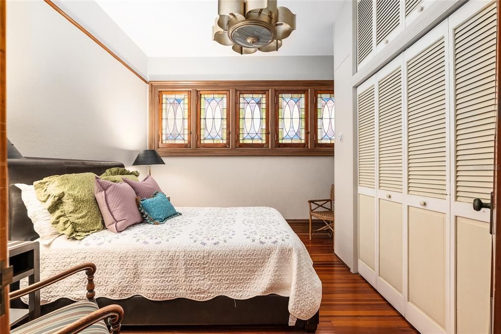 Third bedroom fills with amazing colored light from the stained-glass windows that open for the breeze