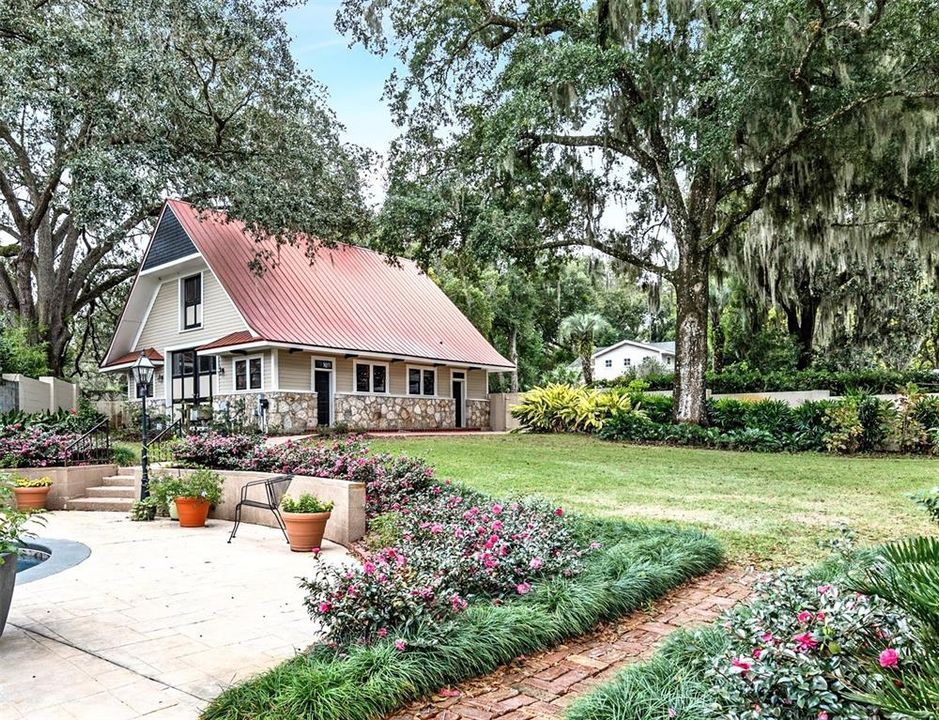Professional landscaping, gardens and sidewalk lead to Carriage House
