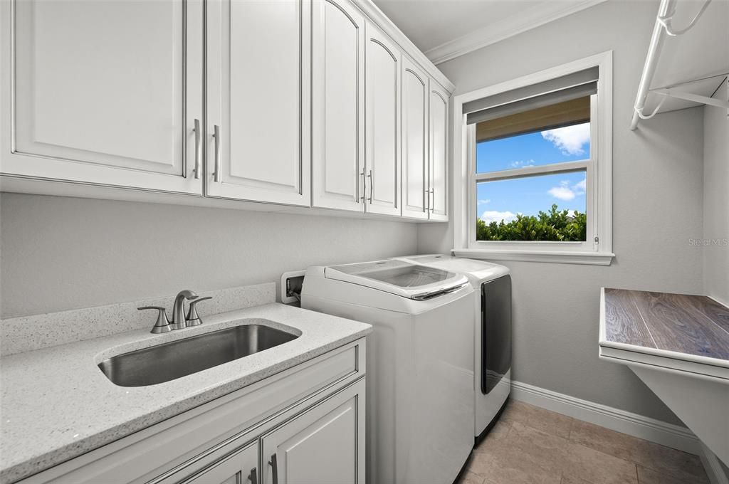 Laundry room with sink, lots of storage and folding area.