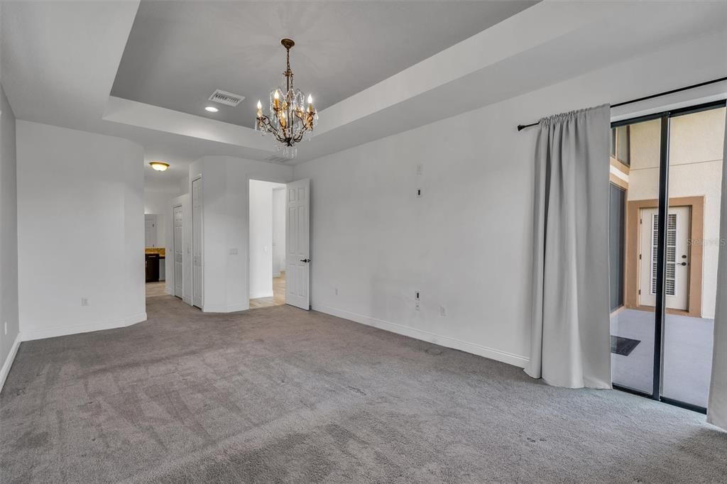 Primary bedroom main floor with sliding door to rear of home