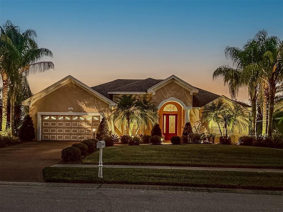 Strategically Placed Landscape Lighting Enhances The Beauty Of This Spectacular Home At Night.