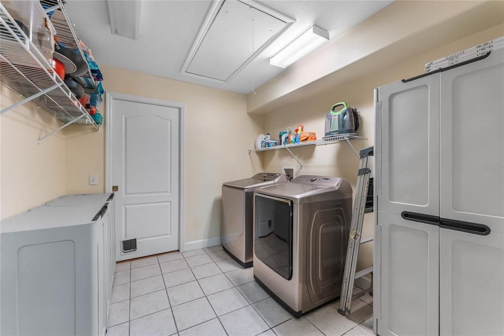 Large laundry closet with shelving and additional storage space