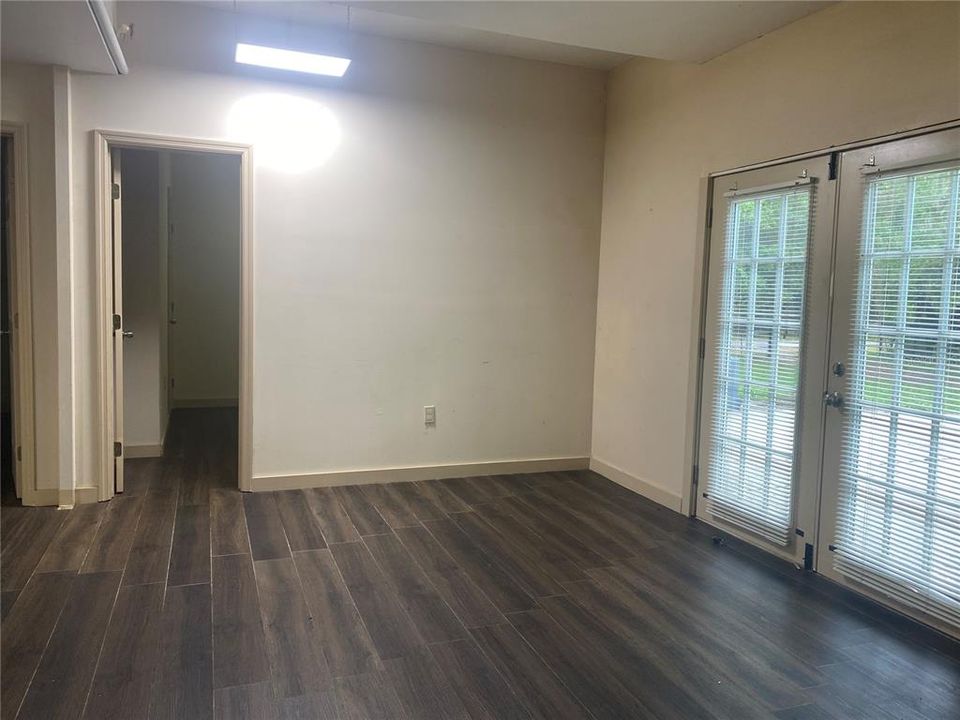 Living room in the downstairs unit.  French doors in the front add lots of natural light.  Door at the back left leads to the 10.6' x 11' bedroom.