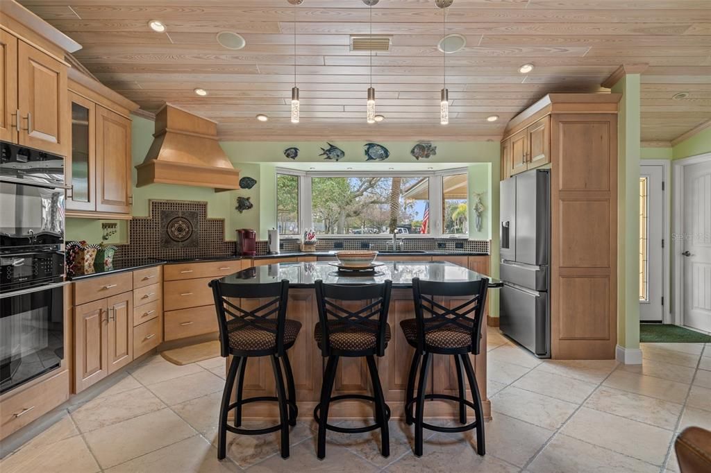 The spacious custom built island kitchen features plenty of counterspace, cabinets , cupboards, and storage.