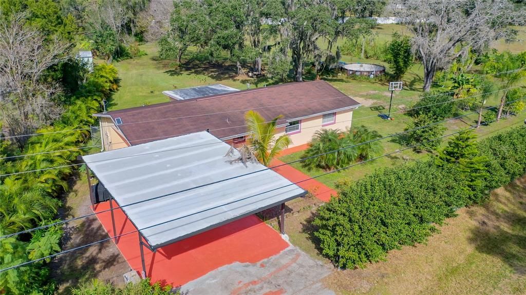 Carport with the tree lined electric gate