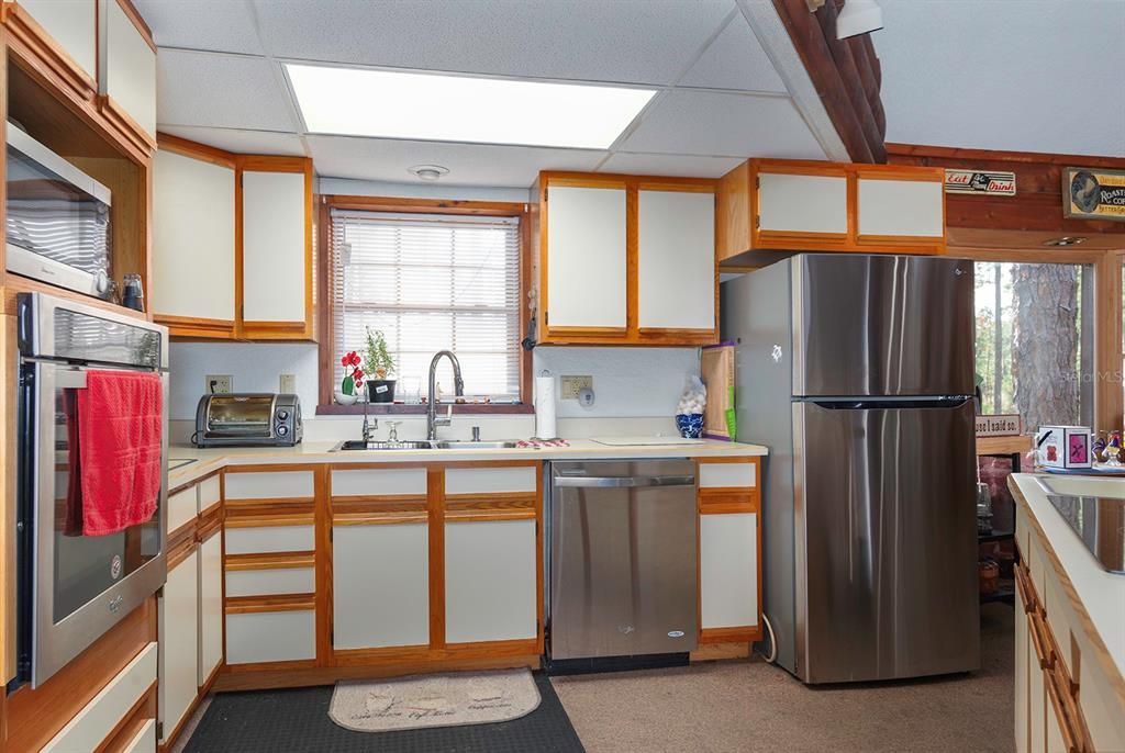 The kitchen has oak and formica cabinets with formica countertops. Fridge is 1 year old, brand new disposal and cooktop!