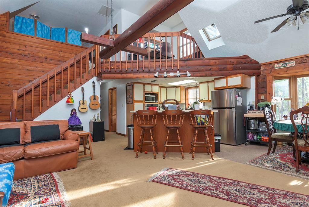 From the front door you see the open floor plan stairs and loft above.