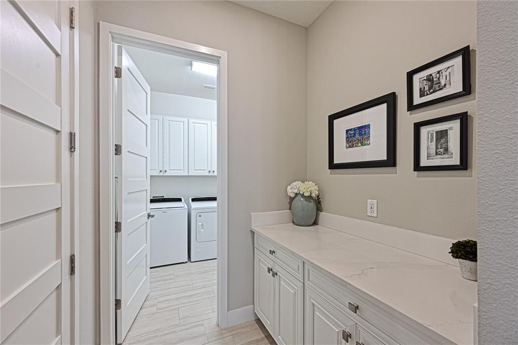 Side hallway to laundry with counter space and storage.