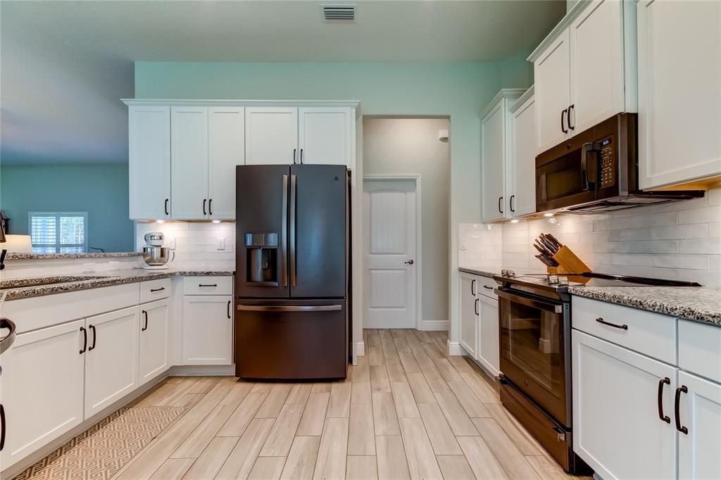 Kitchen, lighted cabinets and laundry room out across the hallway