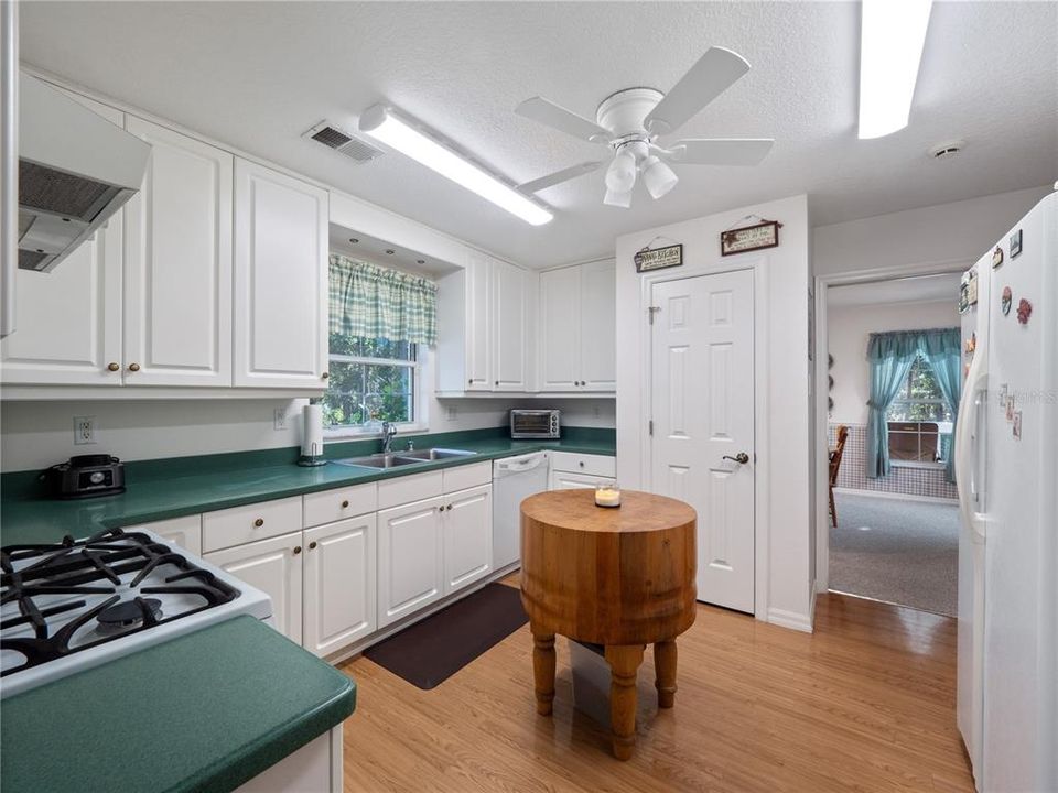 Kitchen Features White Appliances and a Closet Pantry