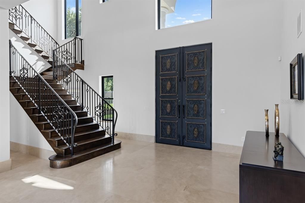 Grand entrance with a beautiful, imported Spanish iron-wrought door and staircase.