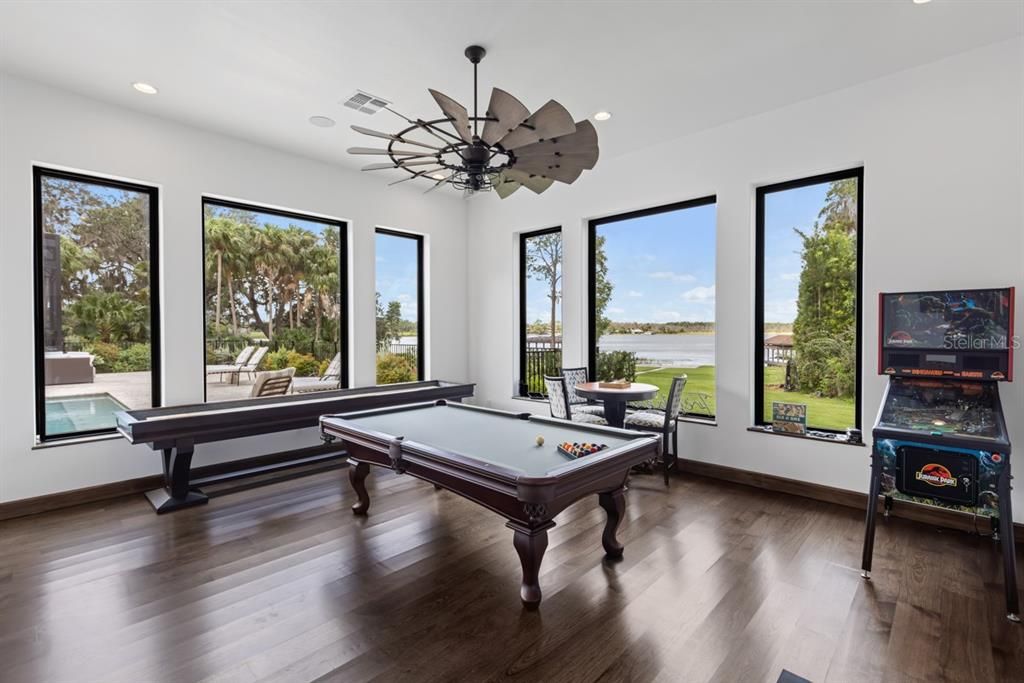 Game room offers stunning lake and pool views, a backdrop for relaxation and social gatherings.