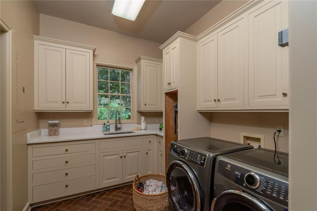 Laundry room with built-in cabinetry and sink.