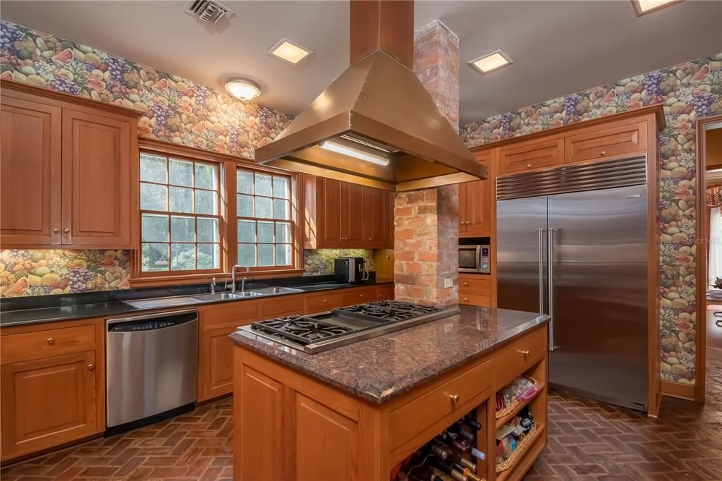 Huge center island in kitchen with custom vent hood.