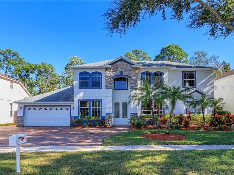 Inviting entrance with fresh paint, paver driveway that has been sealed, designer entrance lighting, and impressive double entry doors!