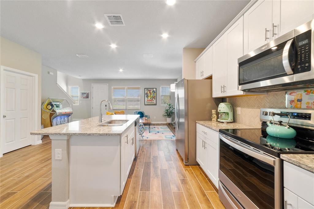 The home chef will appreciate the open layout of the kitchen making entertaining family and friends a breeze with a large center ISLAND with breakfast bar seating, STAINLESS STEEL APPLIANCES, stylish shaker cabinetry and a pantry for ample storage!